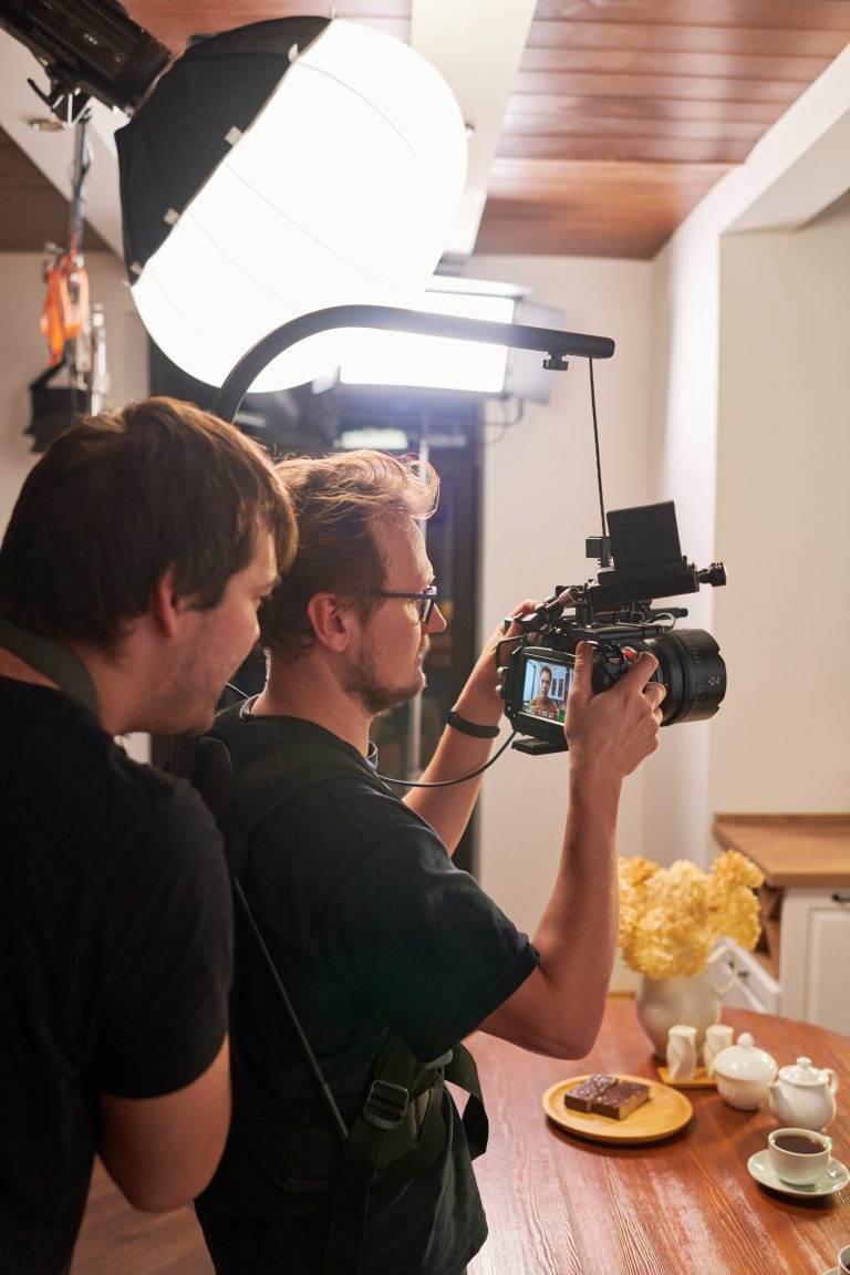 Young videographer and his assistant preparing video camera for